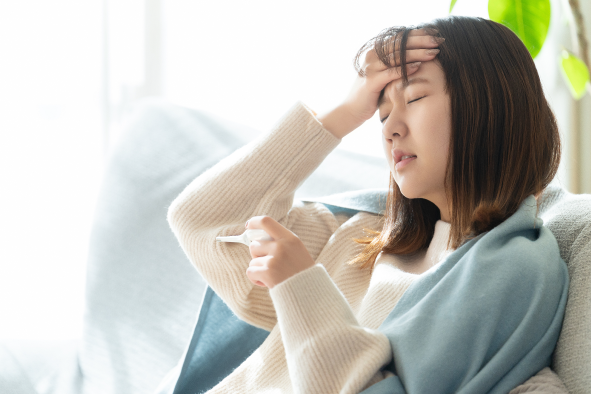熱が出てつらそうな女性の様子